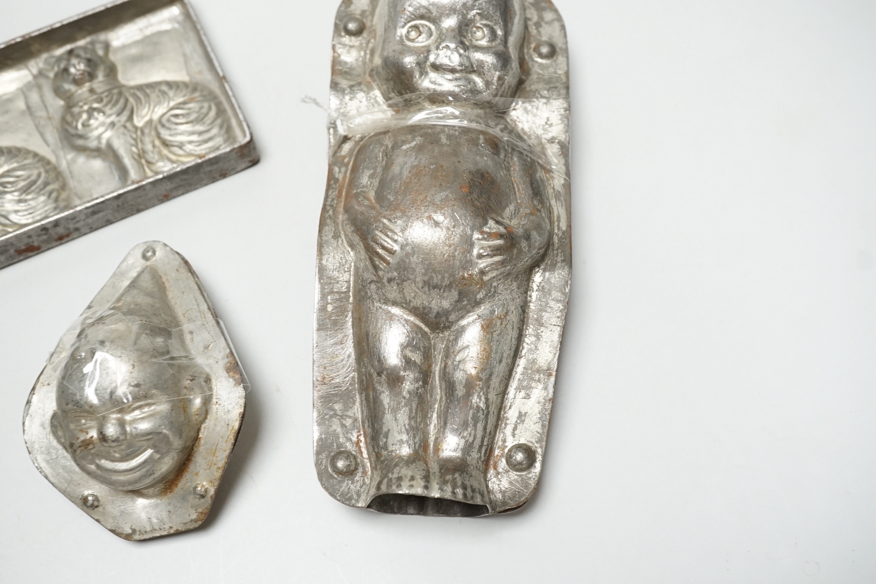 Four chocolate mould tins: a cat, a kewpie and two others